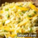 Wood bowl with green napa cabbage, mango slices, and green onions.