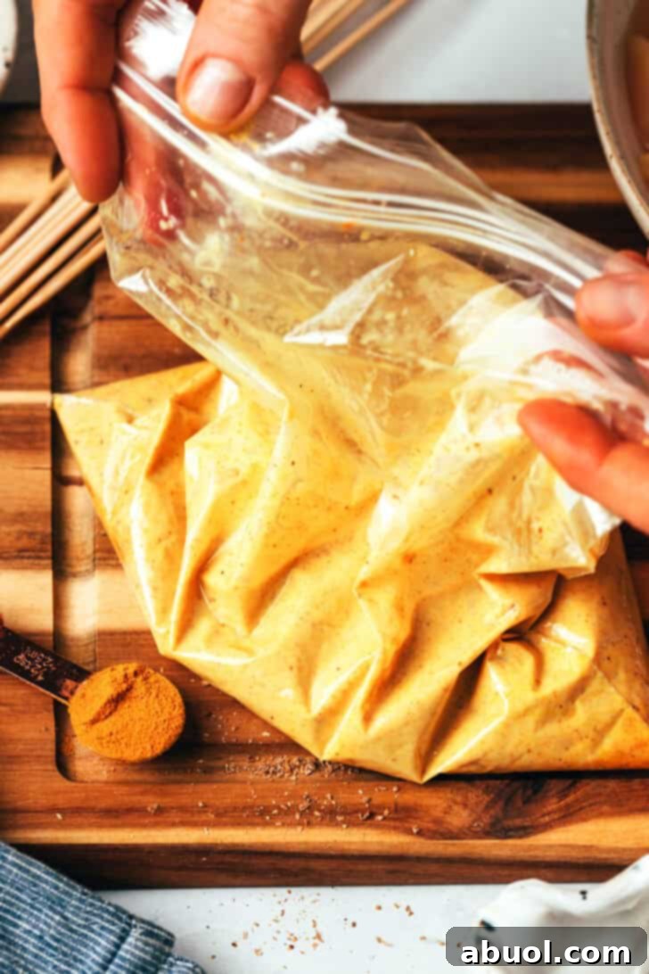 Ziploc bag filled with satay sauce and pieces of chicken.