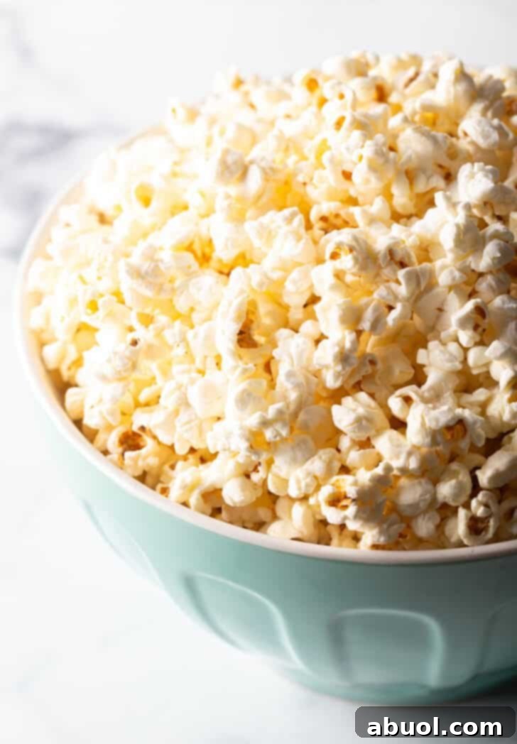 Blue bowl overflowing with butter popcorn.
