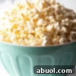 Blue bowl overflowing with butter popcorn.