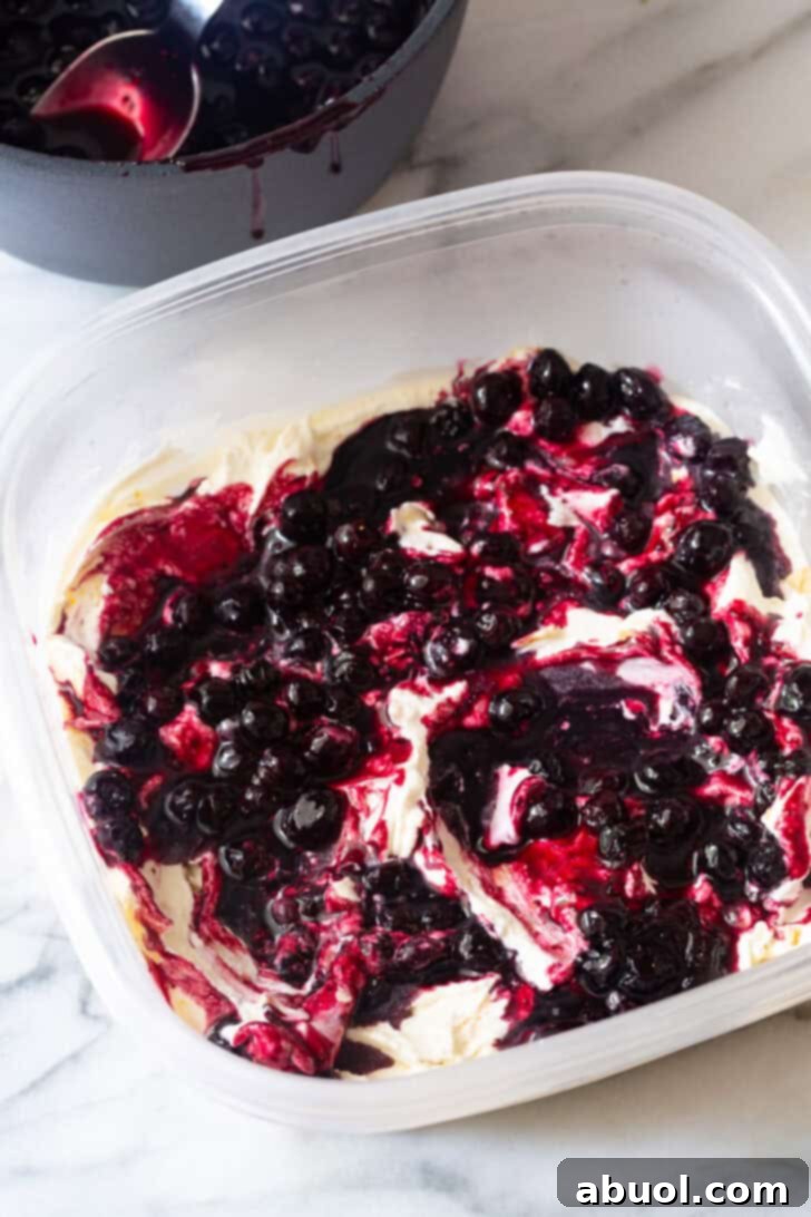 Swirling cooked blueberries into the vanilla ice cream base, creating beautiful ribbons of color.