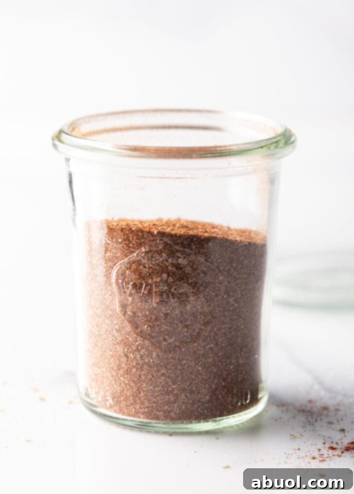 A tall glass jar filled with the homogenous, perfectly blended taco seasoning, ready to be sealed.