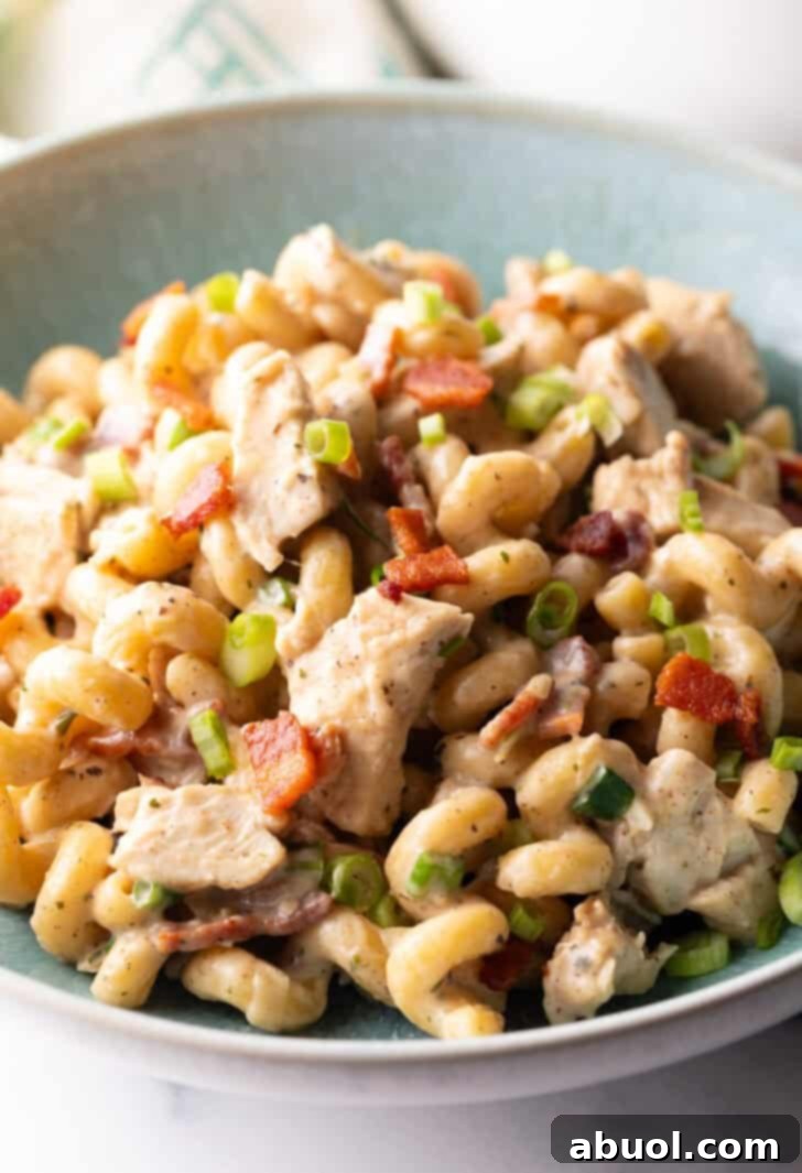Chicken Bacon Ranch Pasta recipe close up in a bowl, featuring corkscrew pasta and vibrant green onions.