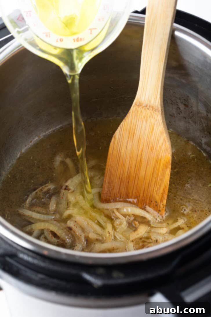 A close-up view of the Instant Pot inner pot, showing onions sautéing, with the addition of beef base, Italian seasoning, and pepperoncini juice, creating a fragrant base for the roast.