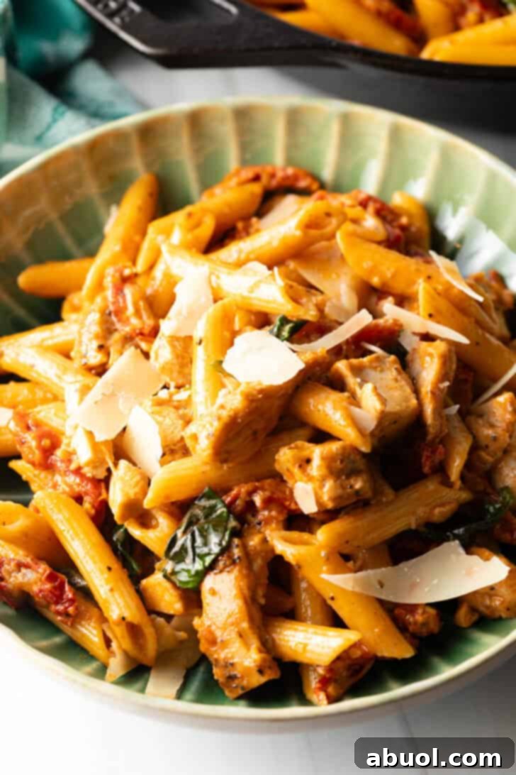 A vibrant green bowl filled with the inviting Marry Me Chicken Pasta, ready to be served.
