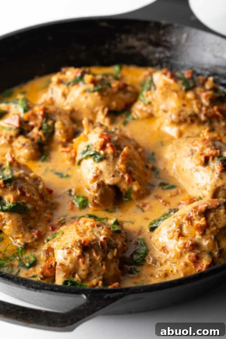 Tuscan Cream Chicken Delights 11 Chicken thighs simmering beautifully in a creamy Tuscan sauce in a cast iron skillet, ready to serve.