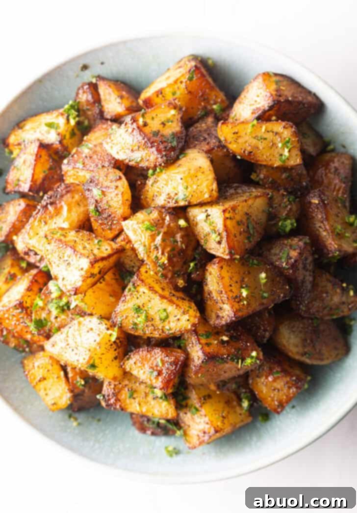 A beautiful top-down shot of a white bowl overflowing with pieces of golden, perfectly crispy Yukon potatoes, ready to be enjoyed.