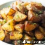 White bowl brimming with pieces of golden crispy Yukon potatoes.