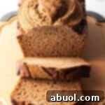 Loaf of healthy banana bread on a cutting board. Two front slices are layered.