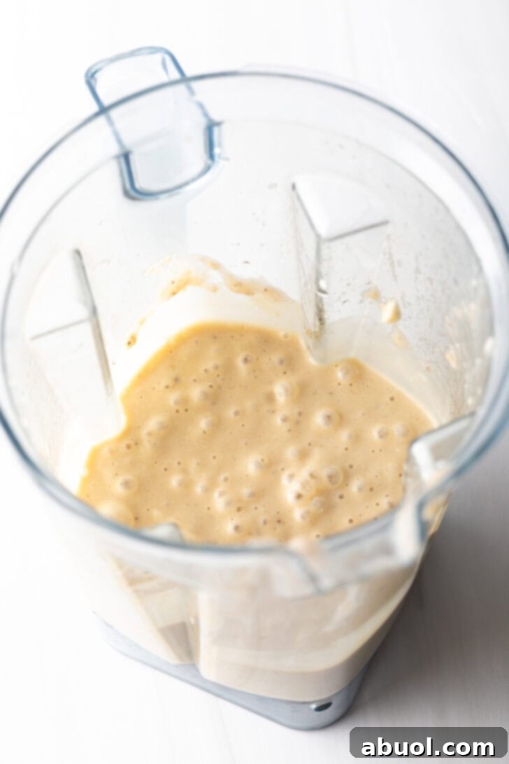 Blender jar after cottage cheese, eggs, and bananas have been combined and pureed into a smooth mixture.