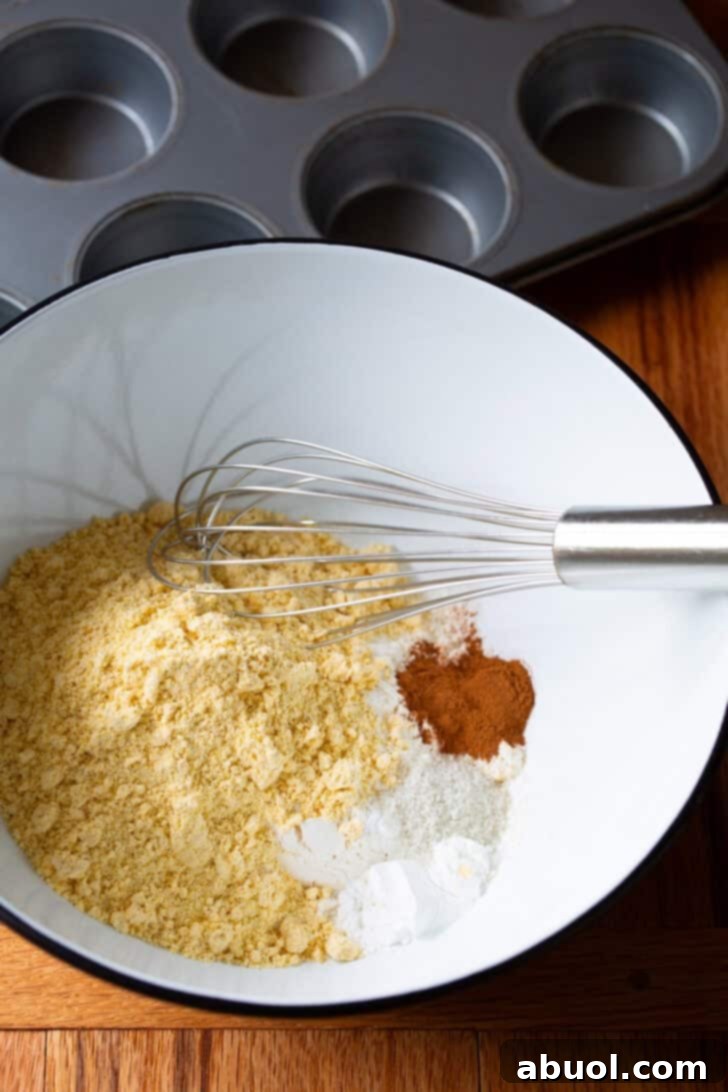 Dry ingredients in a white mixing bowl with whisk.
