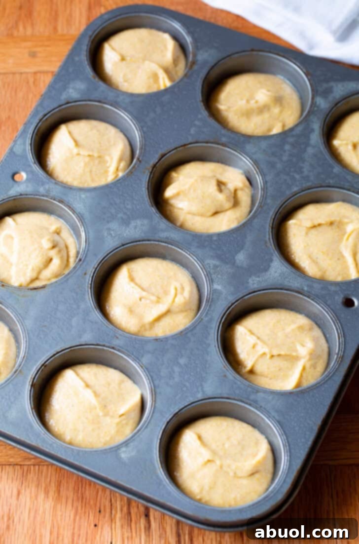Corn muffin batter in a 12 cup baking tin.