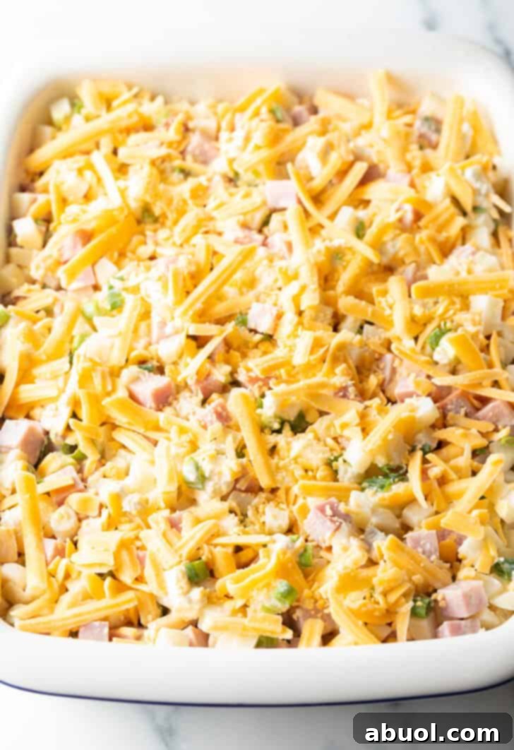 Casserole spread evenly in the dish, topped with remaining shredded cheddar cheese before baking.
