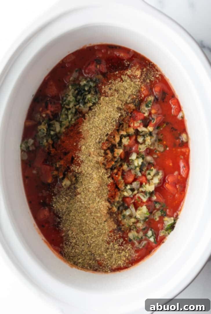 Top down view of a white crock pot with salsa and cooked herbs, ready for the chicken.