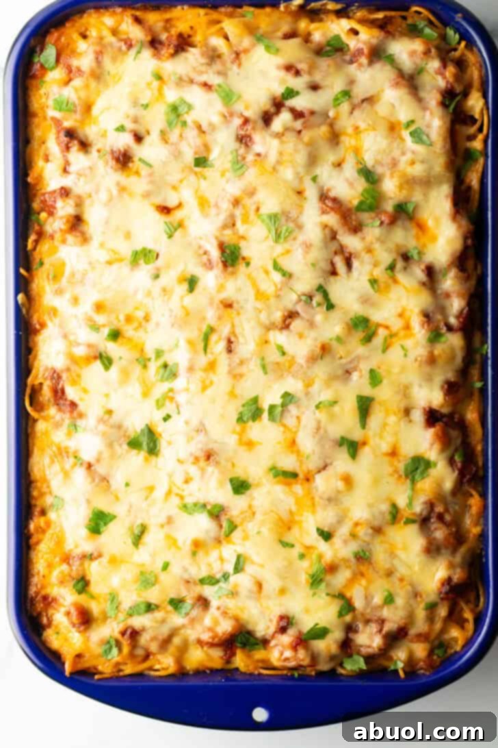 Top-down view of a golden brown, cheesy baked spaghetti casserole fresh out of the oven, bubbly and ready to serve.