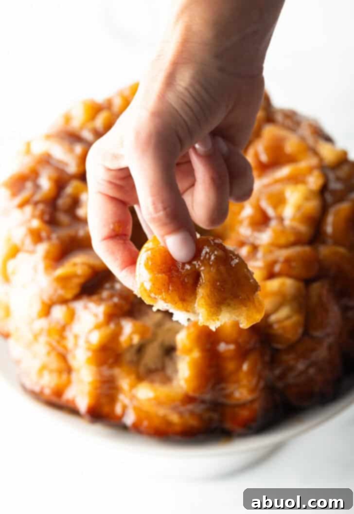 Irresistible Pull-Apart Cinnamon Loaf 15 Hand pulling a baked dough monkey ball from the loaf.