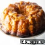 Monkey bread baked in a bundt pan, plated on a white cake stand.