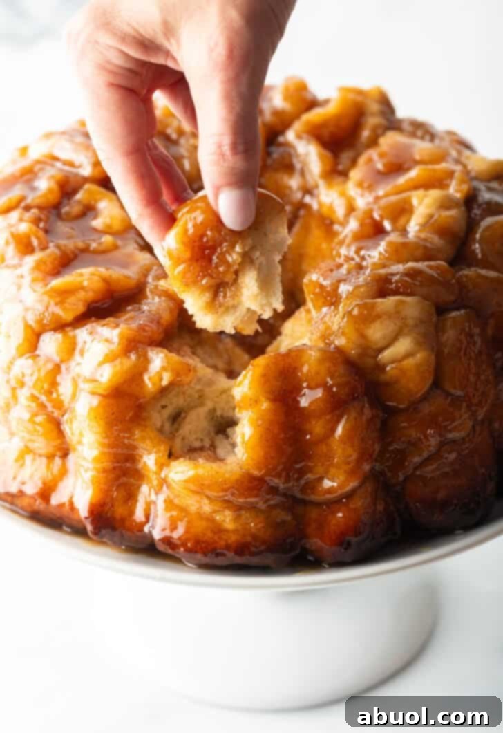 Irresistible Pull-Apart Cinnamon Loaf 4 Hand pulling a baked dough monkey ball from the loaf.