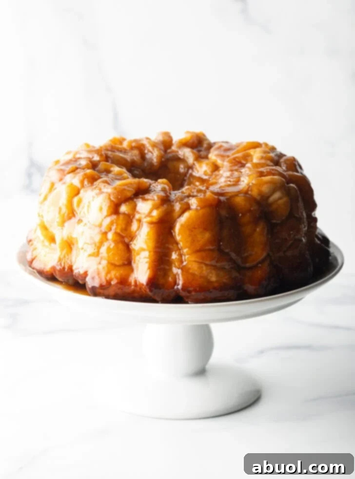 Irresistible Pull-Apart Cinnamon Loaf 5 Monkey bread baked in a bundt pan, plated on a white cake stand.