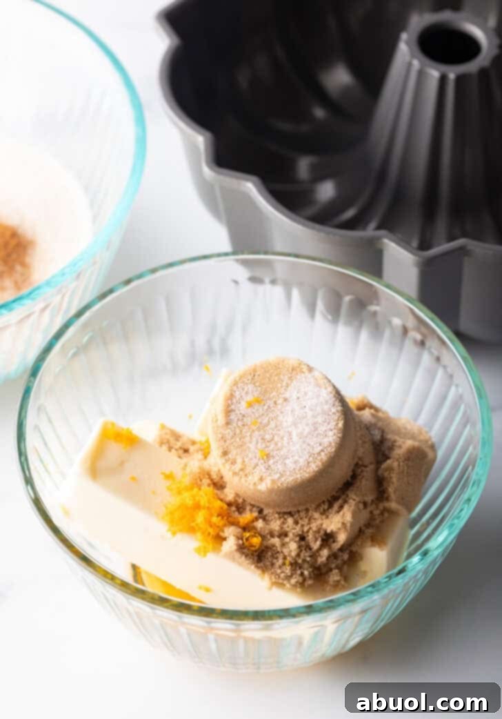 Irresistible Pull-Apart Cinnamon Loaf 9 Glass bowl with brown sugar, orange zest, butter, and pumpkin pie spice.