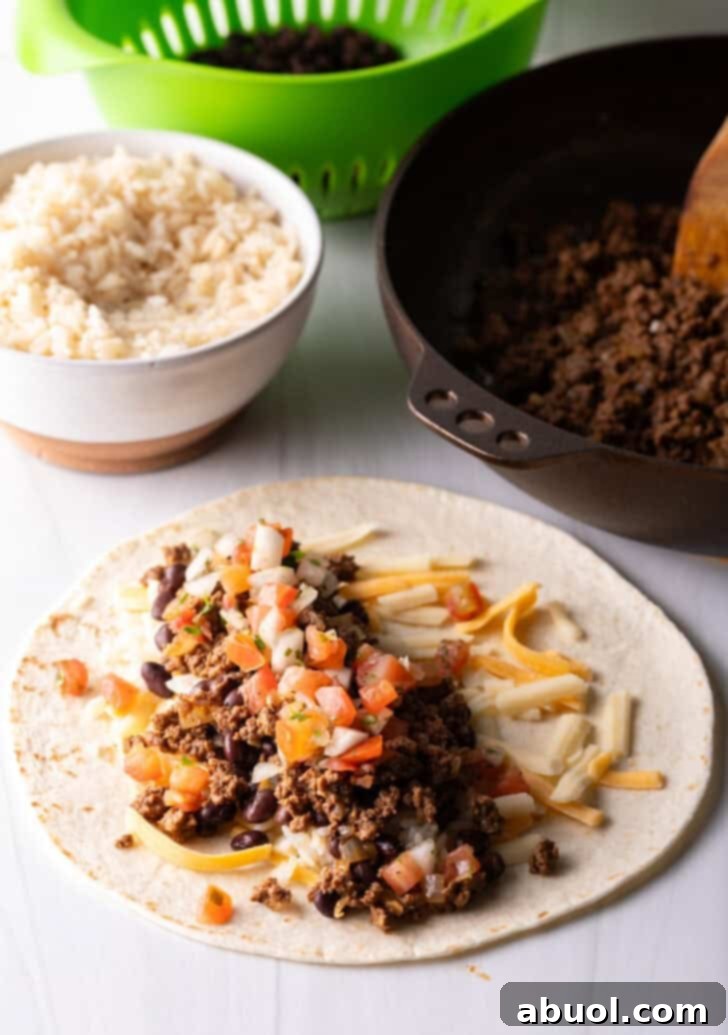 Open-faced flour burrito with shredded cheese, beans, and ground beef.
