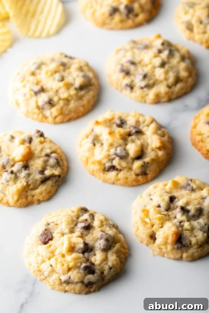 Salty Sweet Crunch Cookies 5 Baked potato chip cookies cooling on a white surface, ready to be enjoyed.