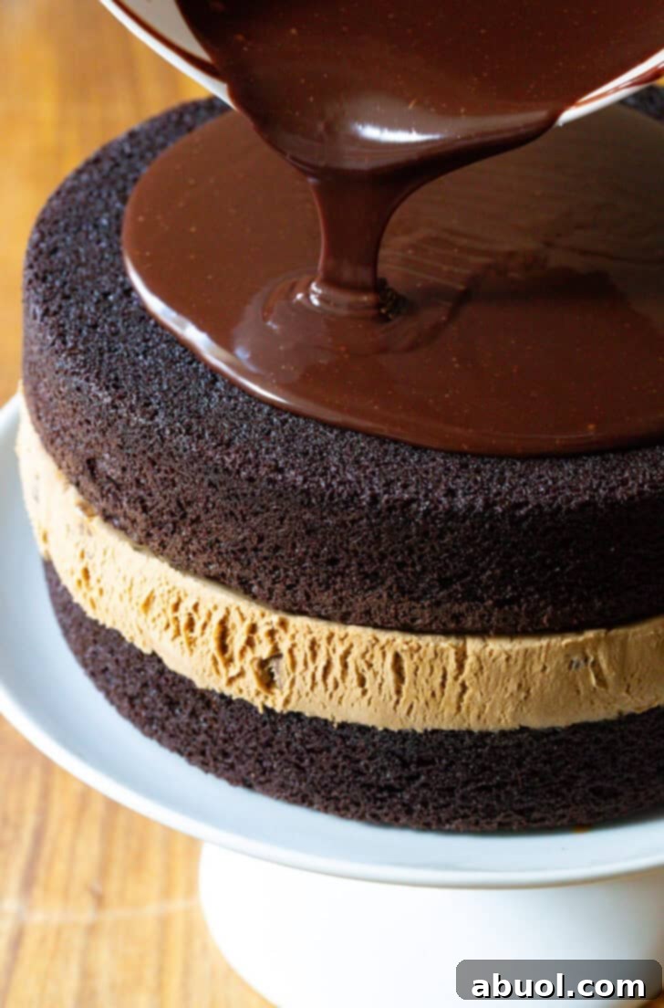 Homemade Ice Cream Cake Bliss 10 Pouring melted fudge frosting overtop a chocolate and caramel layered ice cream cake.