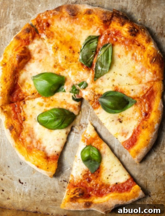 Crafting Perfect Neapolitan Pizza Dough 18 Top down view of a baked Neapolitan pizza with fresh basil leaves.
