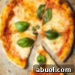 Top down view of a baked Neapolitan pizza with fresh basil leaves.