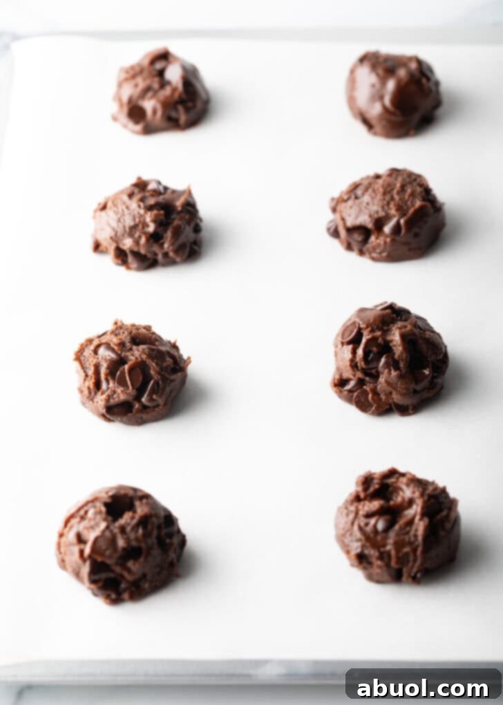 8 balls of chocolate and nutella cookie dough on a baking sheet.