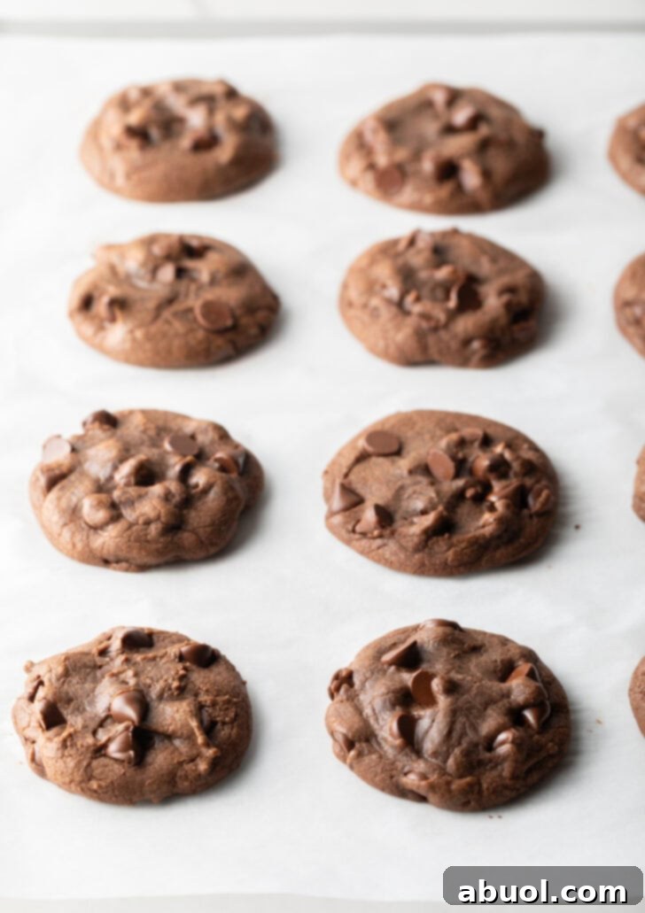 4 baked chocolate hazelnut cookies on a baking sheet.