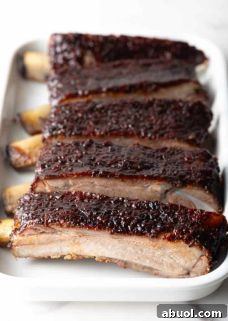 Ultimate St Louis Pork Ribs 12 Six barbecue pork ribs sliced on a white tray.