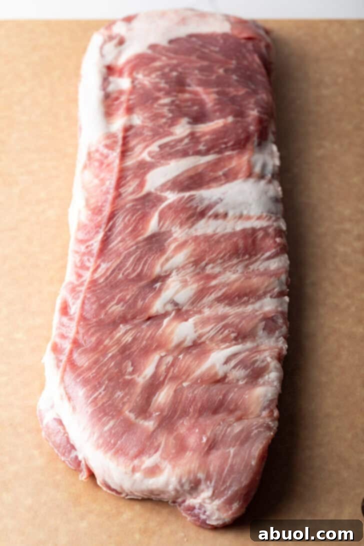 Ultimate St Louis Pork Ribs 6 Overhead shot of a raw rack of pork ribs on a cutting board.