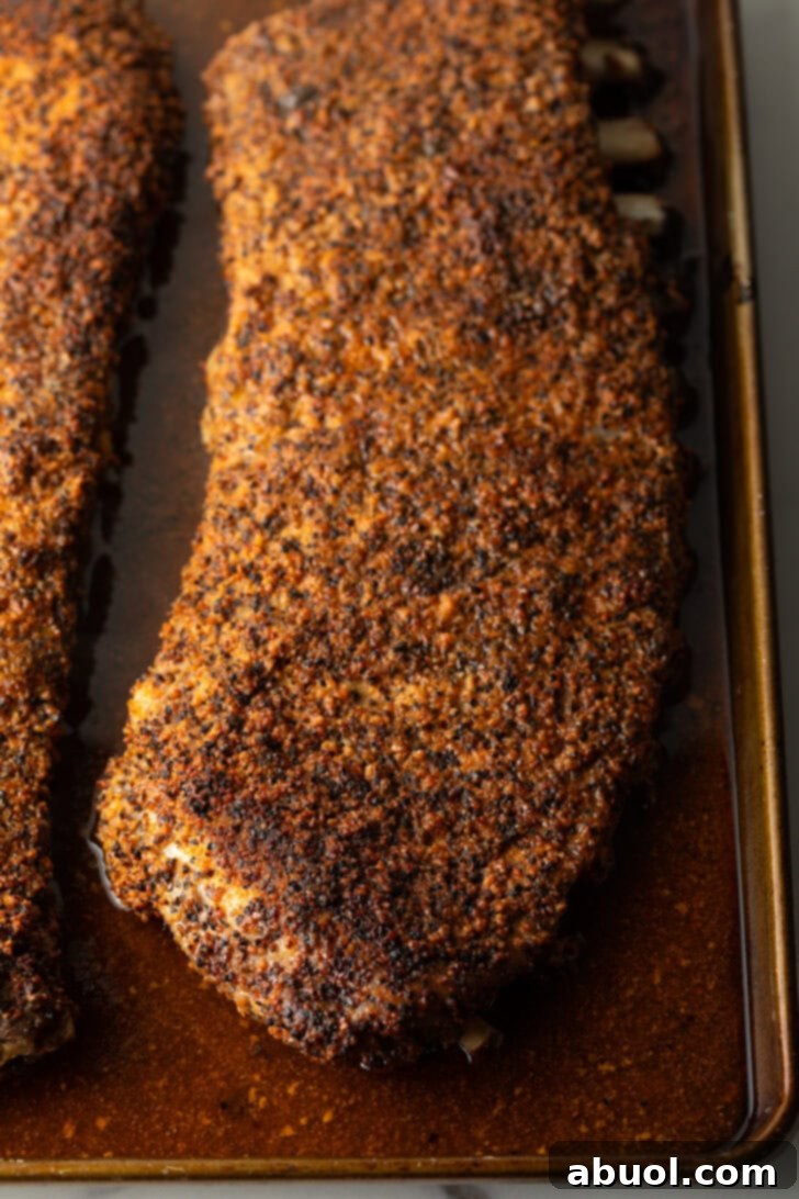 Ultimate St Louis Pork Ribs 9 St Louis ribs in oven tray after being cooked.