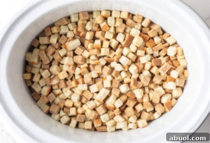 Dried bread cubes in a white crock pot.