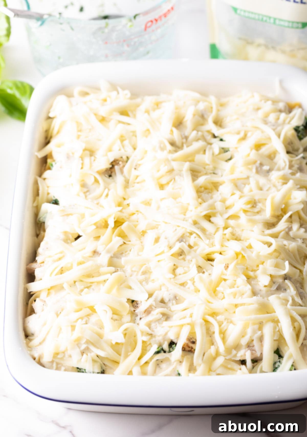 A generous layer of shredded mozzarella cheese evenly spread over the top of the lasagna, promising a perfectly melted, golden crust.