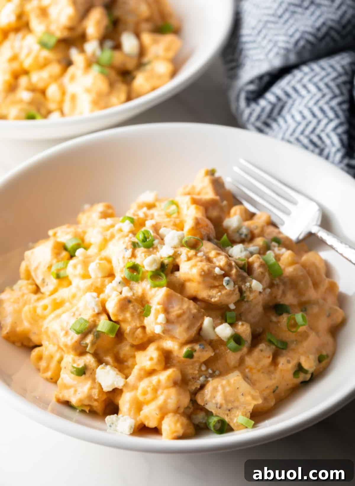 Creamy, cheesy buffalo chicken mac and cheese in a white bowl.