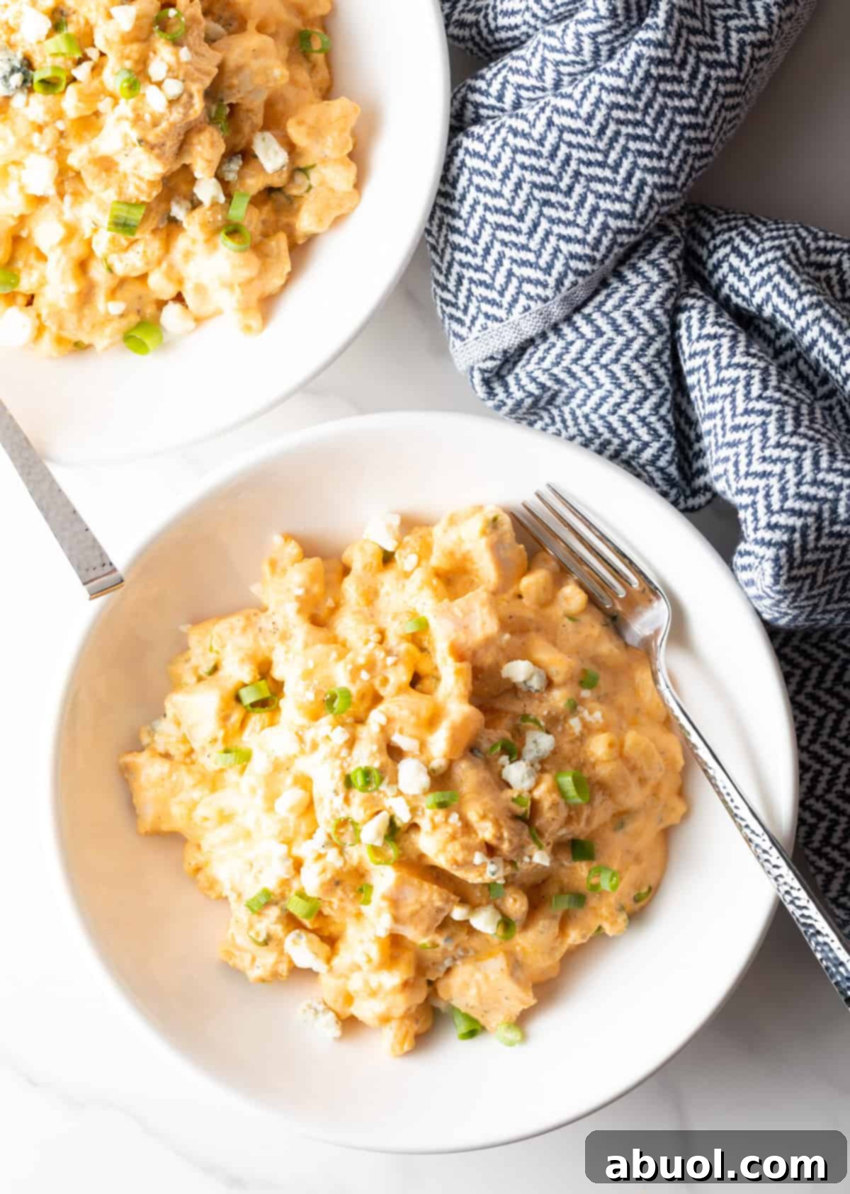 Top-down view of a white bowl filled with creamy buffalo chicken mac and cheese.