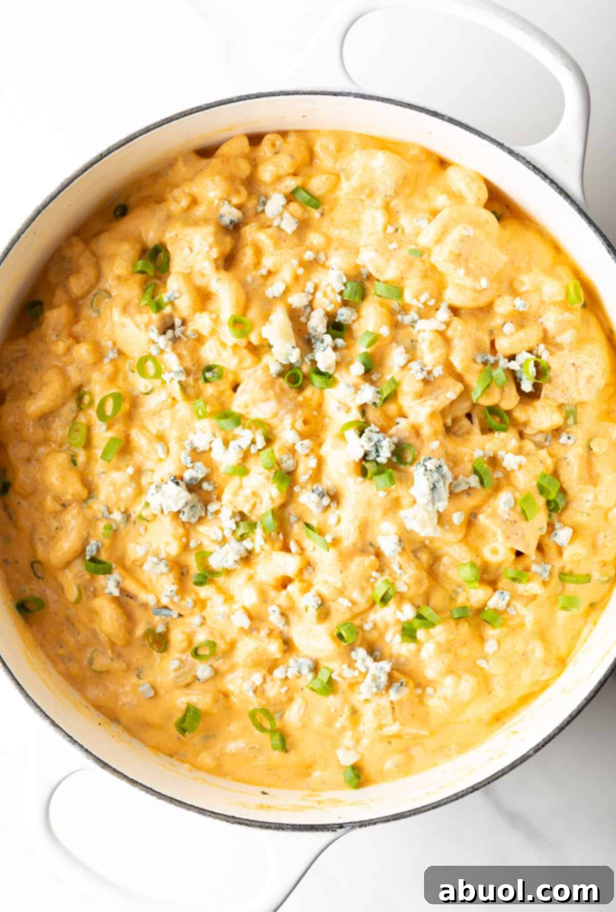 Top-down view of a large pot of buffalo chicken macaroni and cheese.