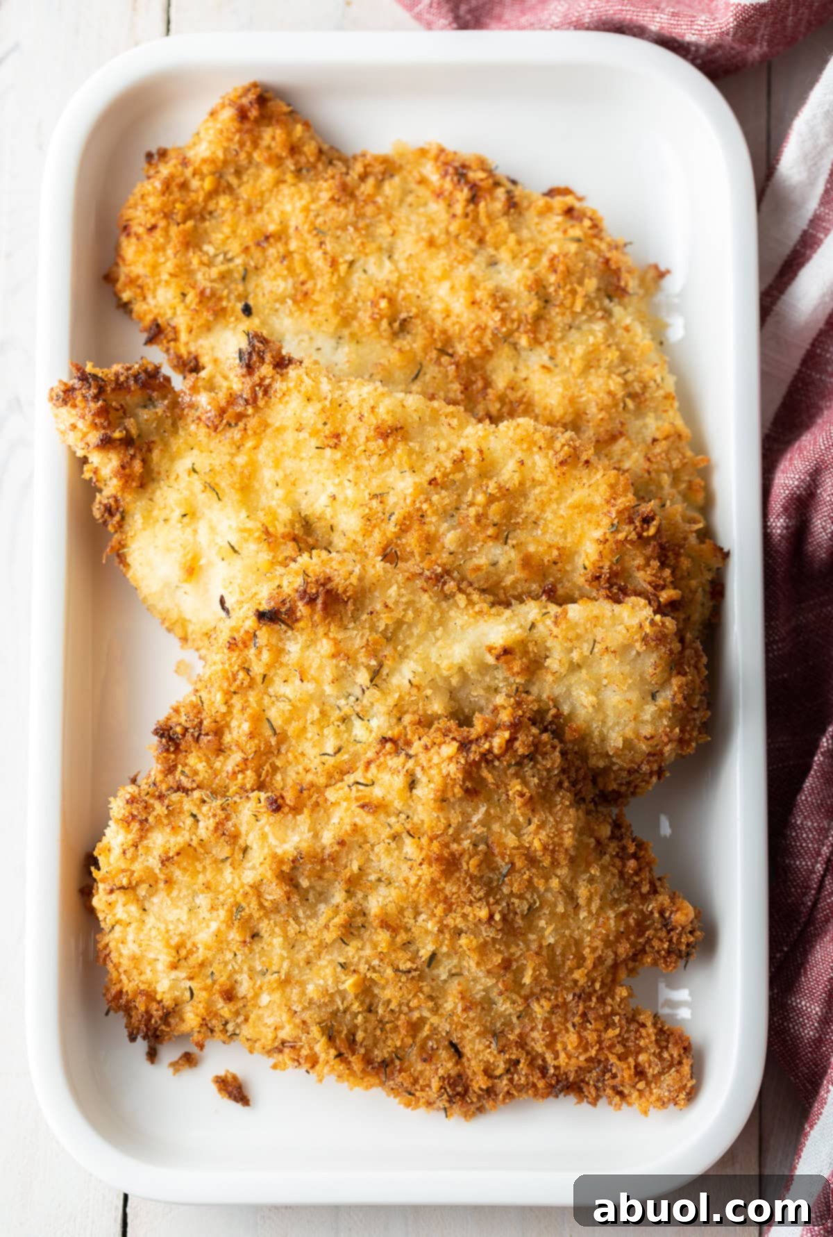 Perfectly baked golden chicken cutlets on a serving platter, garnished with fresh herbs and ready to be enjoyed.