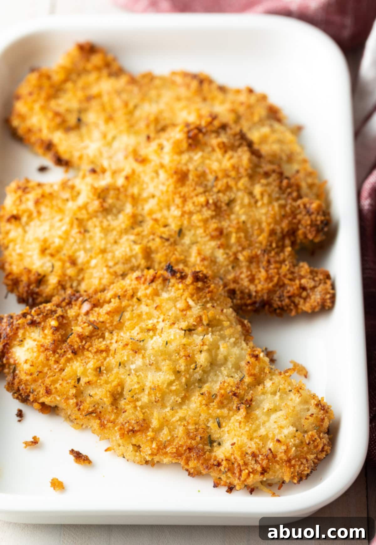 Close-up of perfectly baked breaded chicken cutlets arranged neatly on a platter, highlighting their golden-brown and crispy texture.