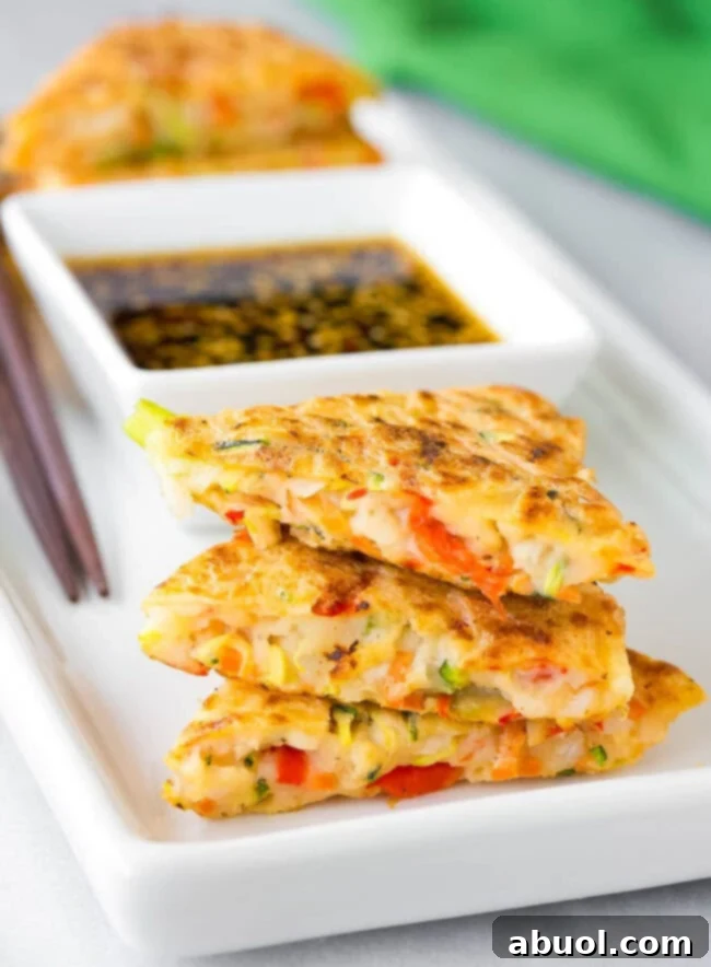 Korean Pancake Recipe #ASpicyPerspective #KoreanPancakes #KoreanPancakeRecipe #Pajun #Pajeon #Korean #Vegetarian An enticing inside view of a freshly cooked Korean veggie pancake, showcasing the vibrant julienned vegetables and tender texture.