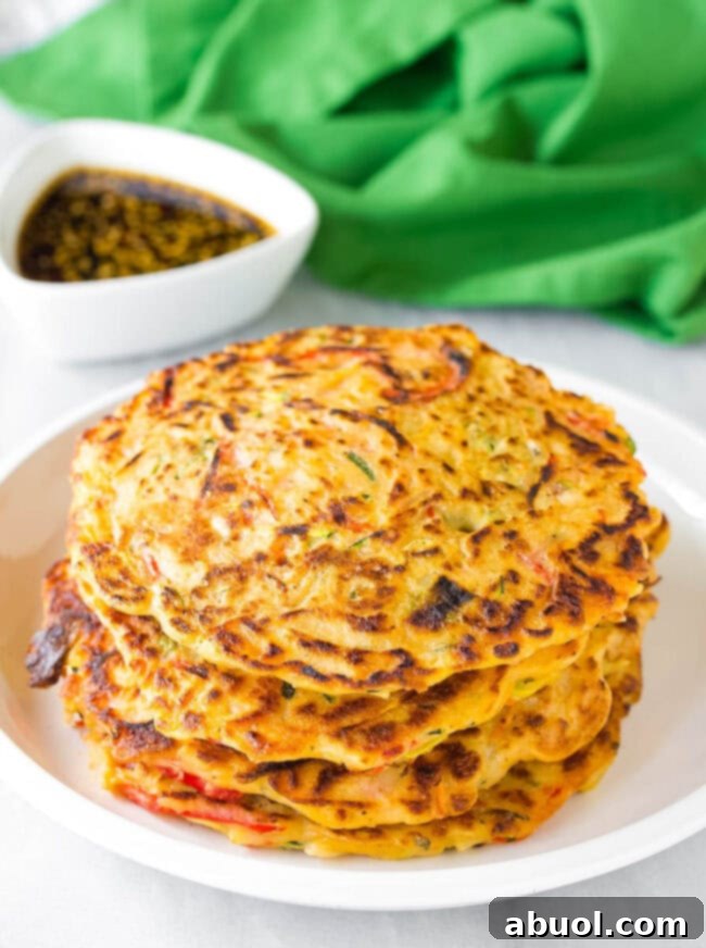Pajun #ASpicyPerspective #KoreanPancakes #KoreanPancakeRecipe #Pajun #Pajeon #Korean #Vegetarian A stack of golden-brown Korean pancakes (Pajun) freshly cooked and ready to be served on a pristine white plate.