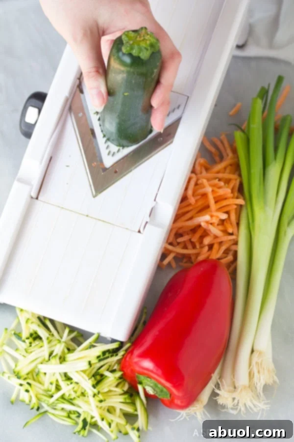 Korean Jeon: Savory Delights 3 A hand expertly using a mandolin slicer to prepare vegetables into thin strips for Korean Pajun, demonstrating a key preparation step.
