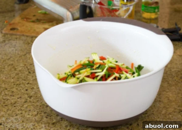 Korean Jeon: Savory Delights 4 A colorful array of freshly julienned vegetables, including carrots, bell peppers, zucchini, and green onions, neatly arranged in a bowl, ready to be mixed into the pancake batter.