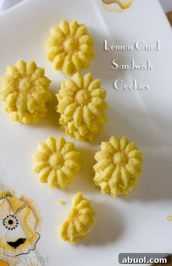 Bright yellow Lemon Spritz Cookies with a fresh, zesty look, made using a cookie press gun.