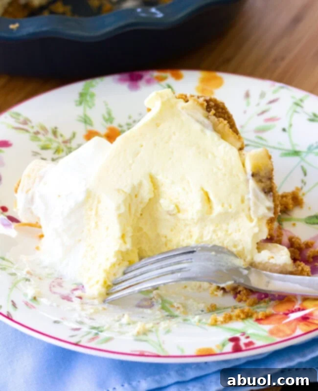 A slice of pie with some missing, and a fork next to it, tempting the viewer to try a bite.
