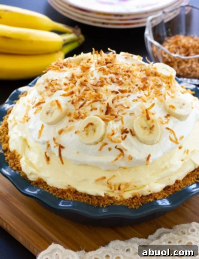 The final Fluffy Banana Cream Pie generously topped with shredded toasted coconut and fresh slices of banana.