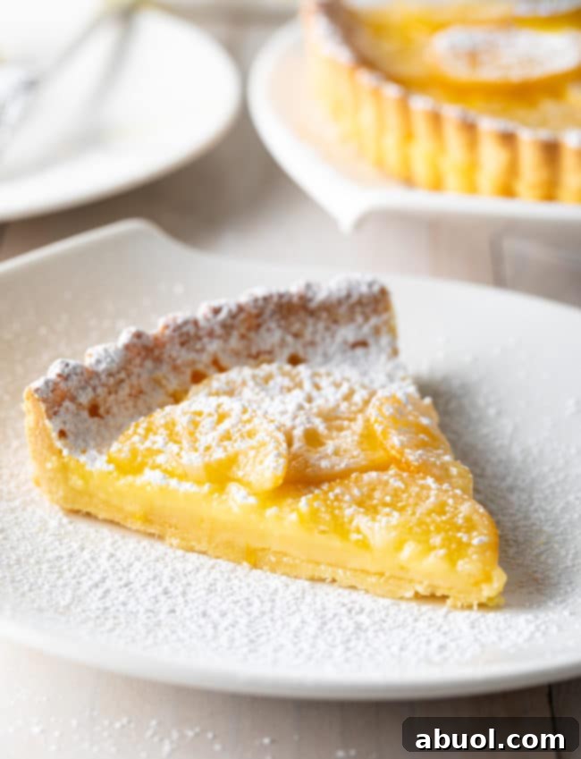 Homemade Lemon Tart Recipe - cut into wedges on white plate.