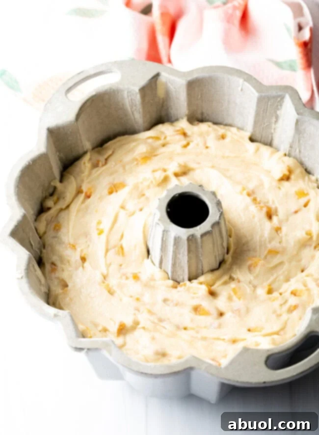 Peach cake batter in bundt pan before baking